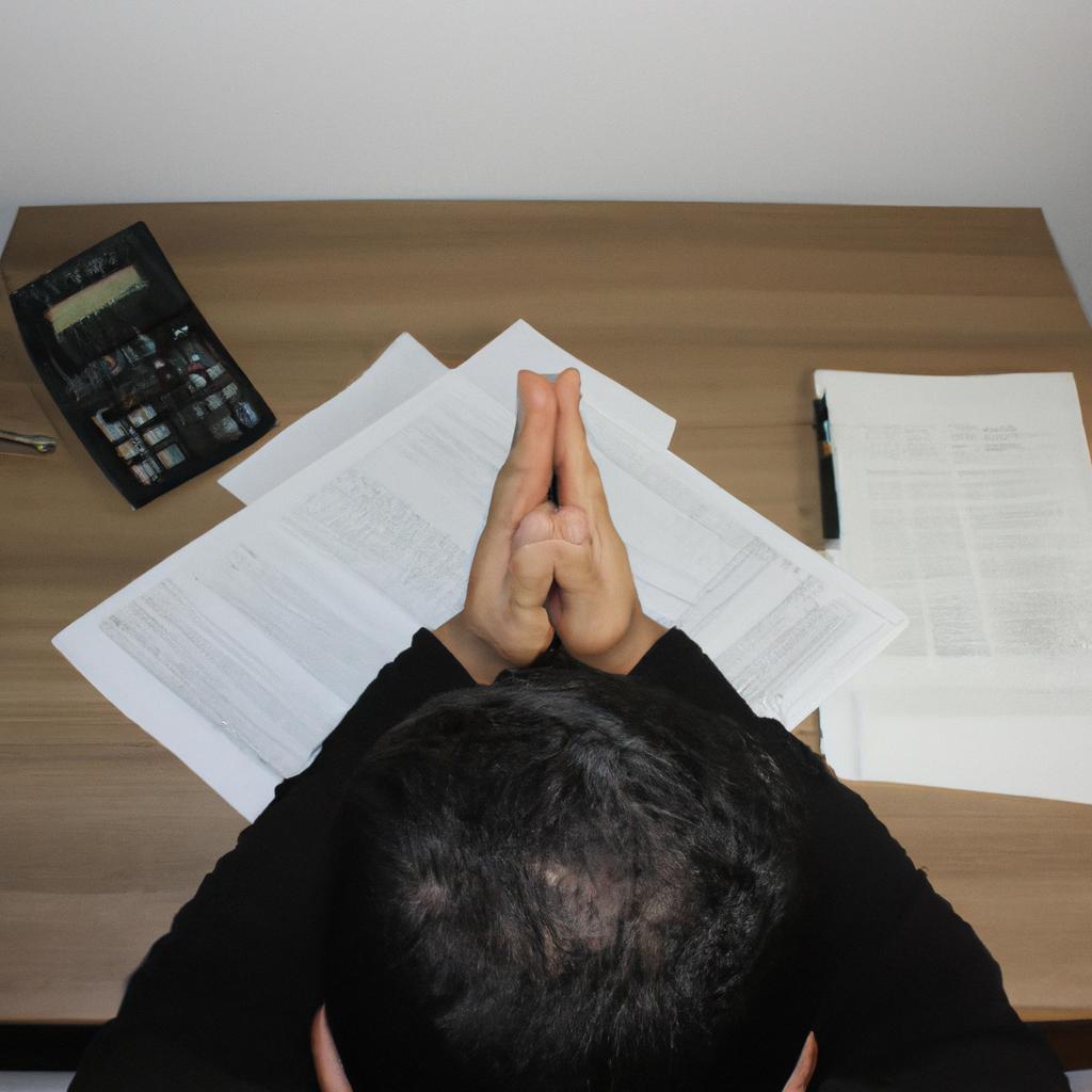 Person praying with financial documents
